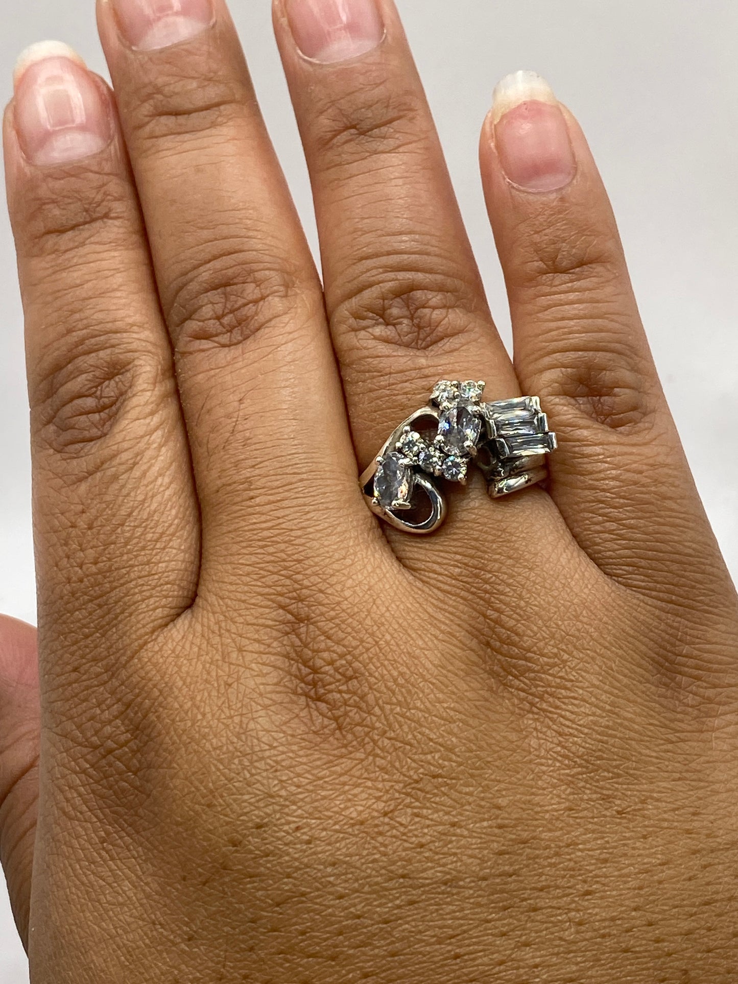 Anillo de plata con circonias en la mano mostrando el brillo y diseño asimétrico