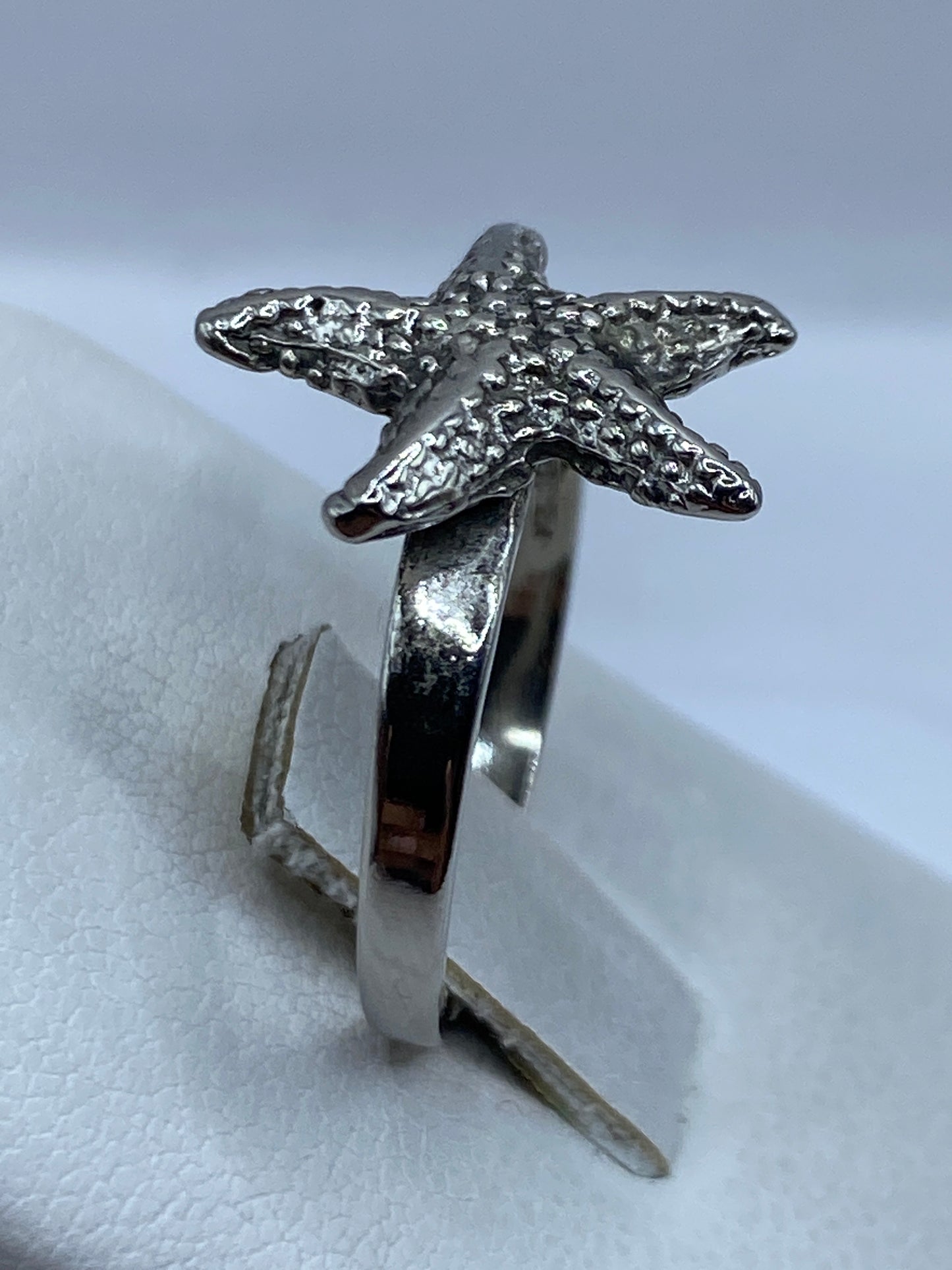 Anillo de plata en la mano mostrando textura artesanal y acabado brillante