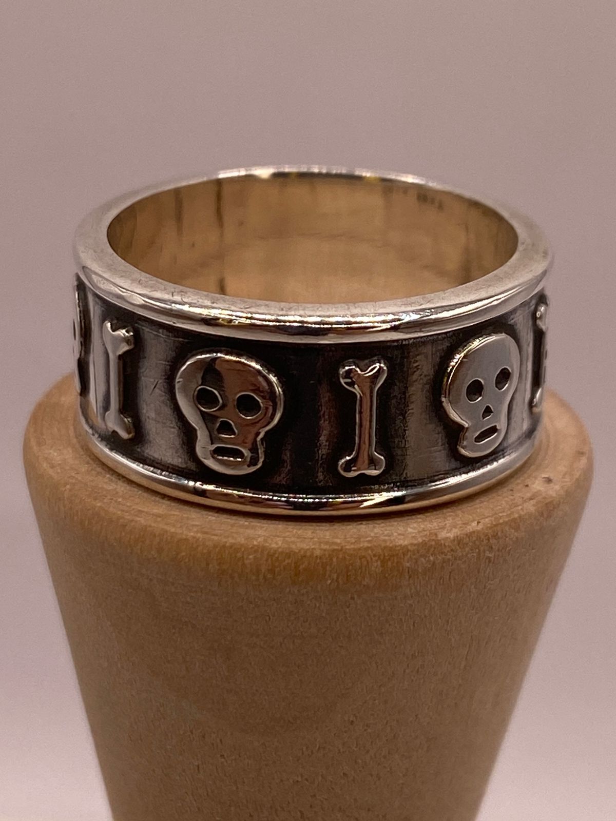Anillo Artesanal en Plata con Calaveras y Huesos en Relieve, vista frontal