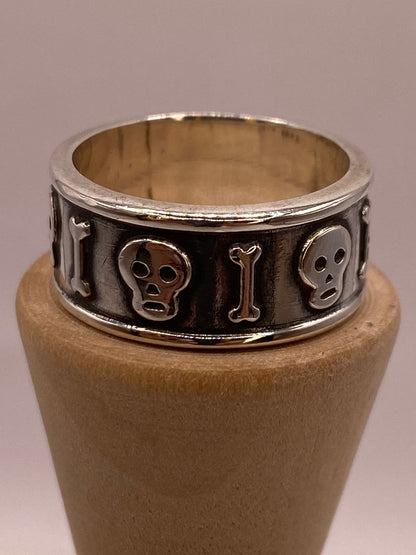 Anillo Artesanal en Plata con Calaveras y Huesos en Relieve, vista frontal