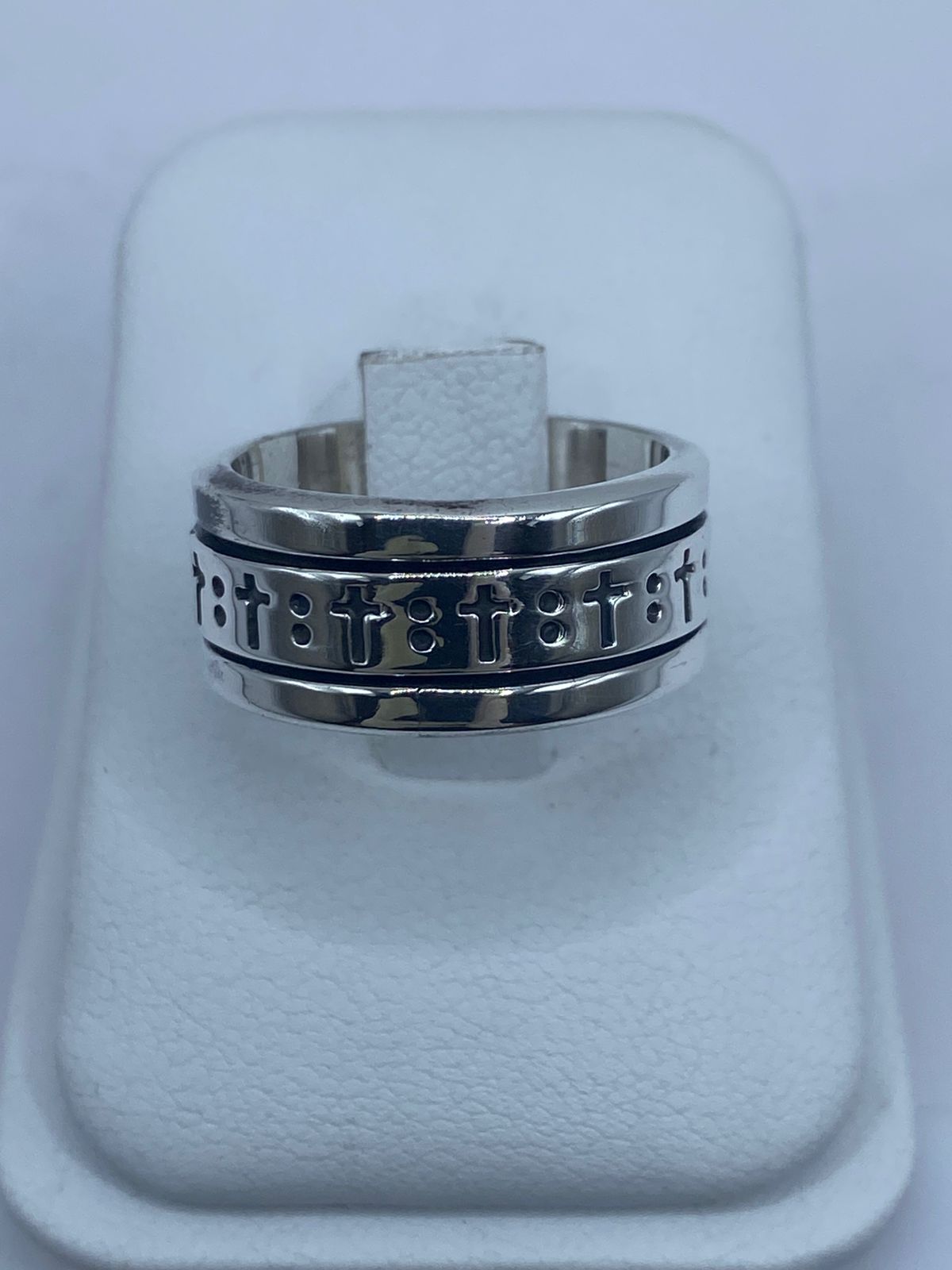 Anillo spinner de plata .925 con cruces grabadas puesto en la mano — antiestrés espiritual artesanal hecho en Taxco
