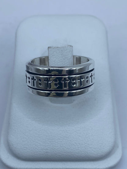 Anillo spinner de plata .925 con cruces grabadas puesto en la mano — antiestrés espiritual artesanal hecho en Taxco
