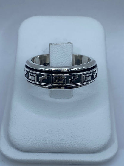 Vista frontal de anillo spinner plata .925 banda ancha con greca meandro en relieve sobre fondo oxidado negro — artesanal Taxco
