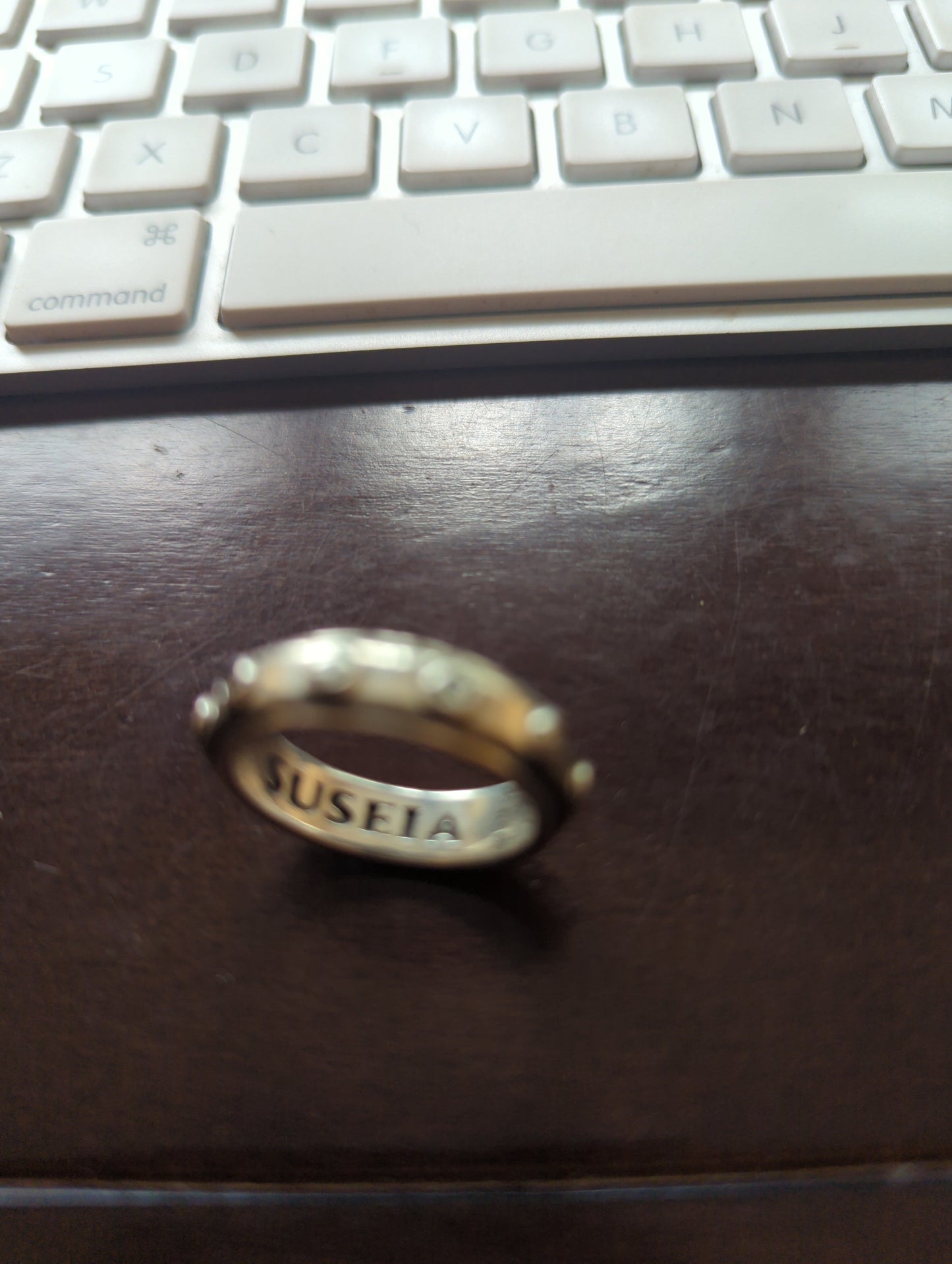 Anillo sello de plata .925 con grabado personalizado SUSEIA, vista frontal sobre fondo oscuro