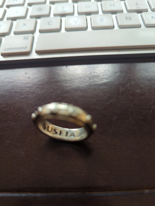 Anillo sello de plata .925 con grabado personalizado SUSEIA, vista frontal sobre fondo oscuro