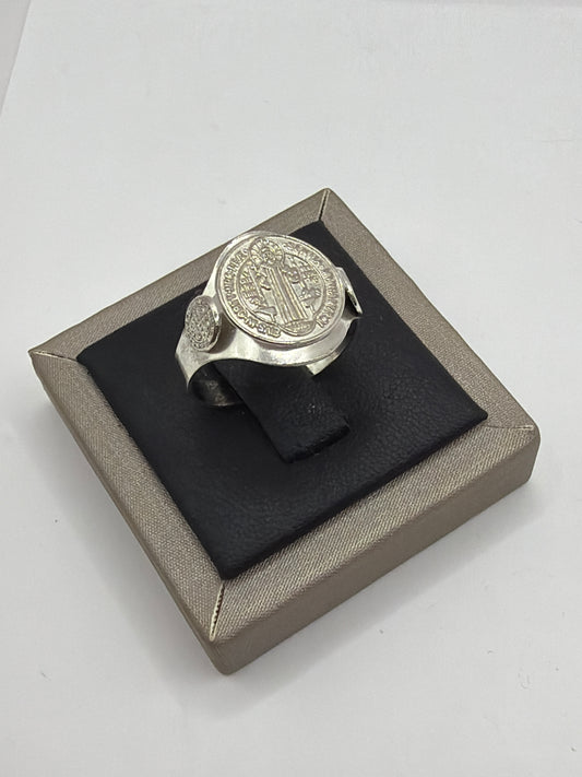 Anillo San Benito en plata .925 sobre caja de presentación, vista frontal con símbolo grabado en el bezel