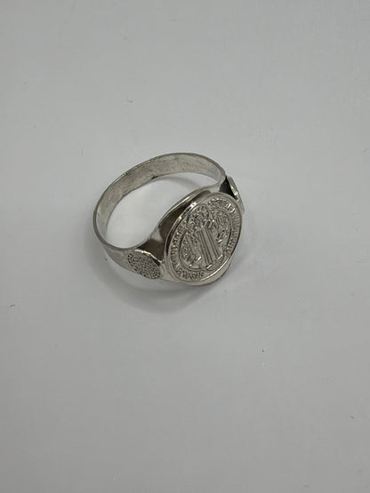 Anillo San Benito de perfil mostrando el aro liso y el simbolo en relieve, acabado pulido