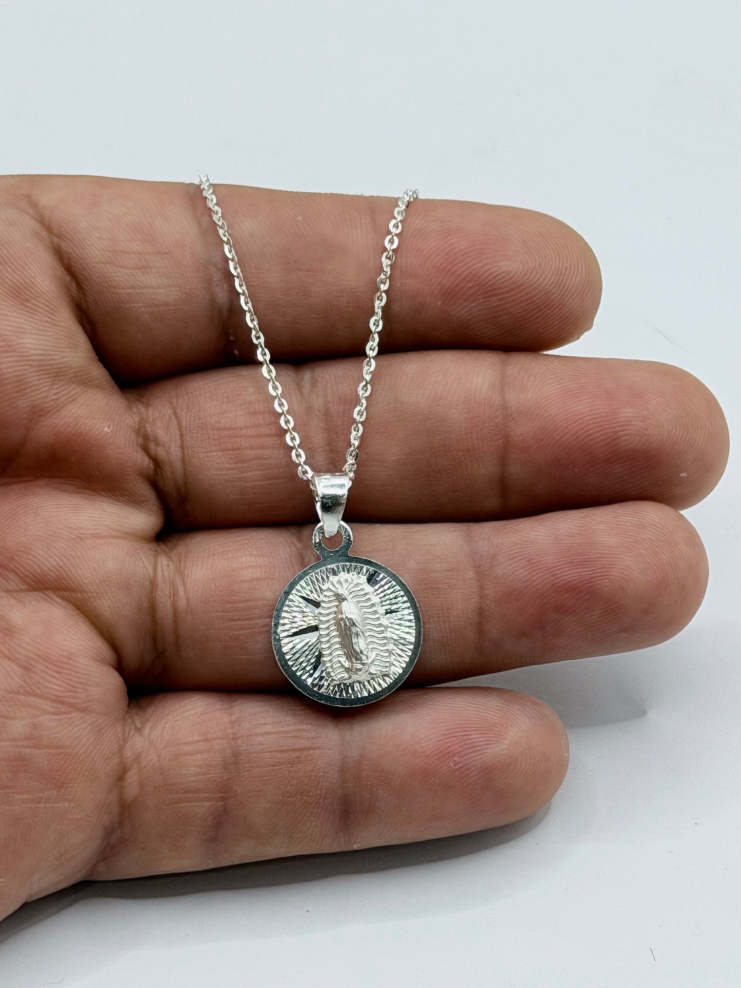 Dije Virgen de Guadalupe en plata pura mostrado en mano, con cadena de 45cm