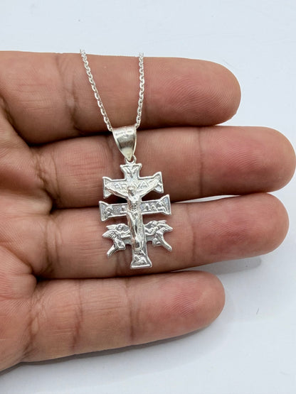 Cruz de Caravaca en plata .925 en la mano, mostrando tamaño y brillo del metal