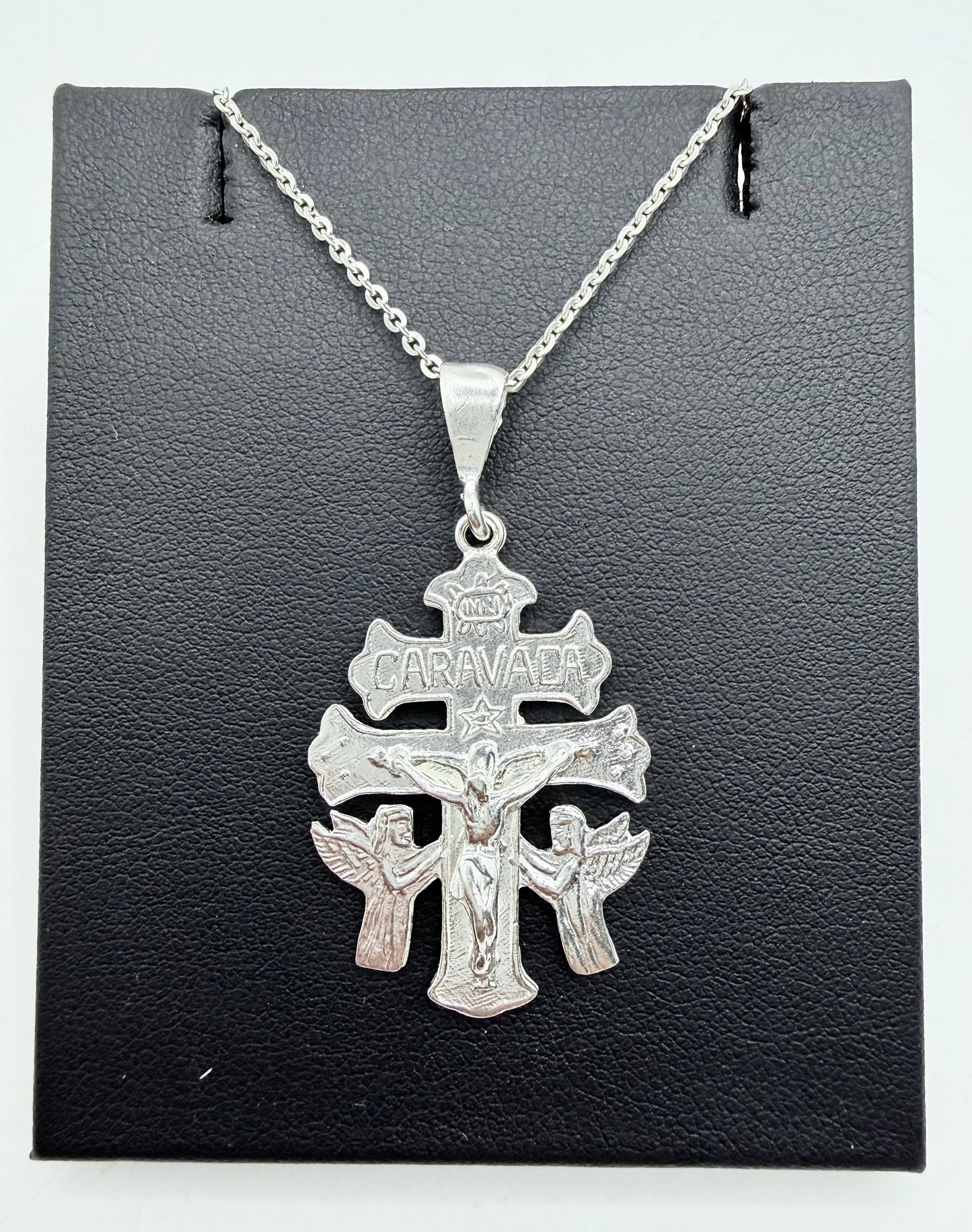 Cruz de Caravaca en plata .925 con cadena, presentada sobre fondo gris — vista frontal del dije con detalles en relieve