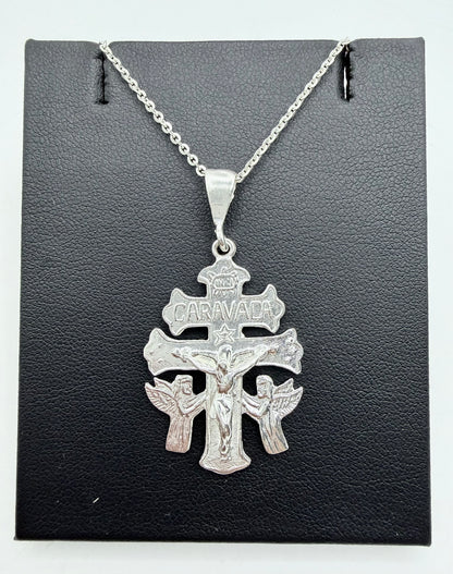 Cruz de Caravaca en plata .925 con cadena, presentada sobre fondo gris — vista frontal del dije con detalles en relieve