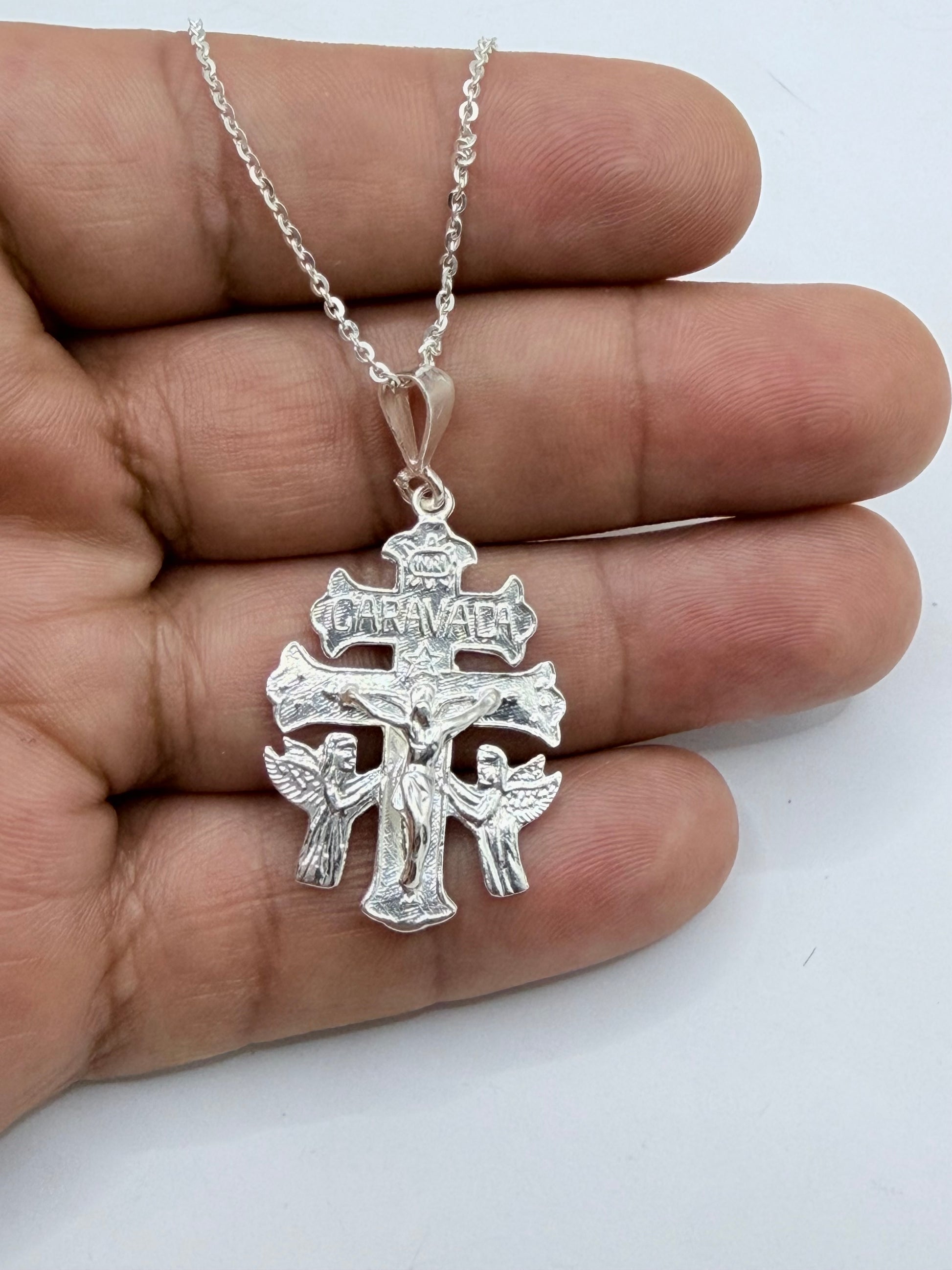 Cruz de Caravaca en plata .925 sostenida en mano — tamaño real, dije de 4.5 cm de alto con cadena de 50 cm