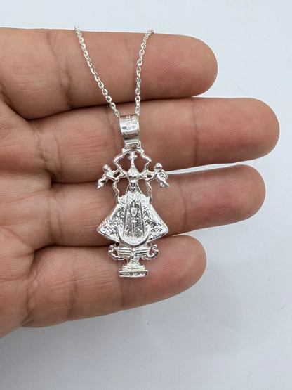 Collar Virgen San Juan de los Lagos en la mano, mostrando proporción y detalles de fundición en plata