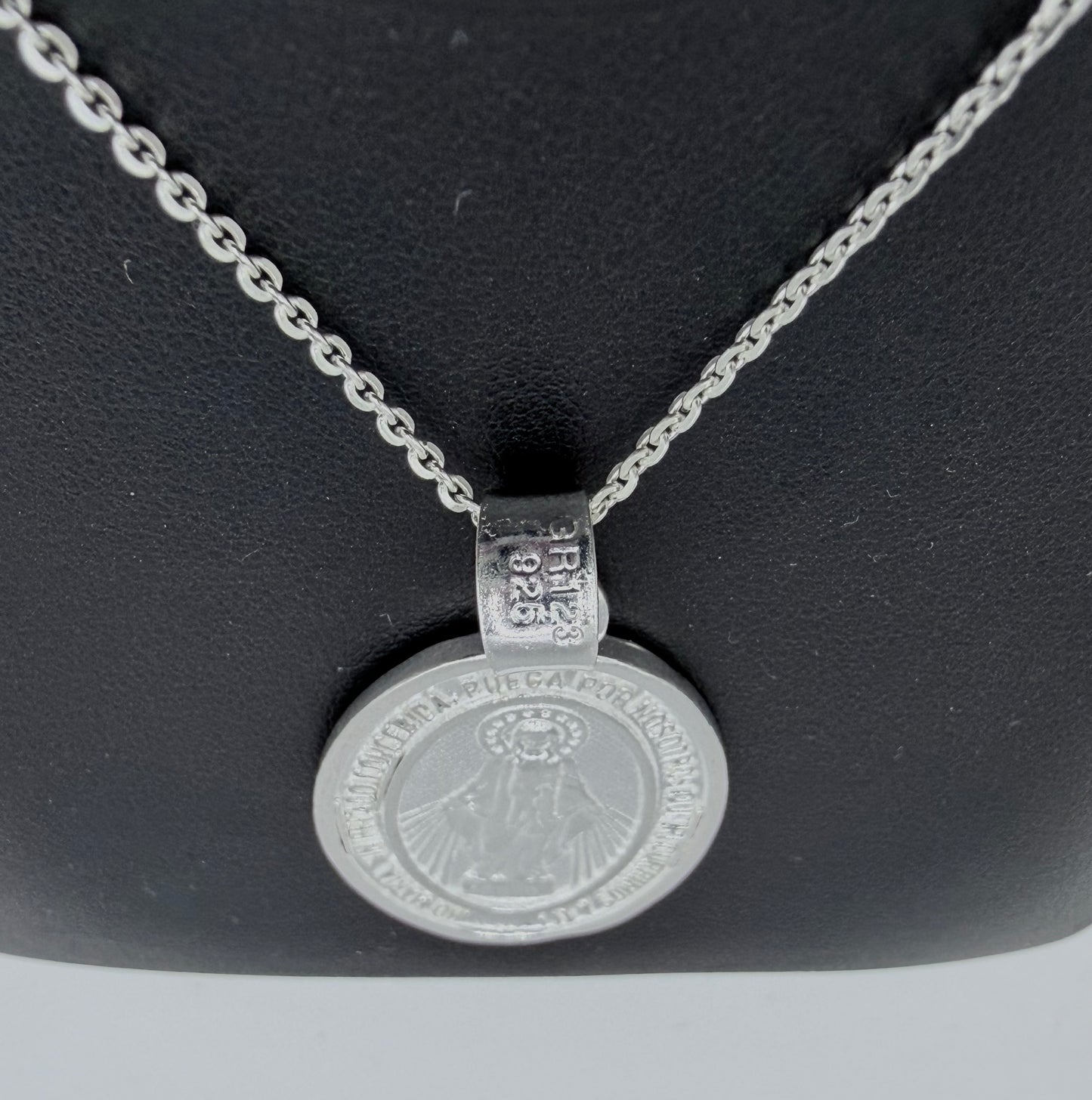 Detalle de medalla religiosa con relieve de la Virgen María, fundida en plata pura, con hallmark Taxco