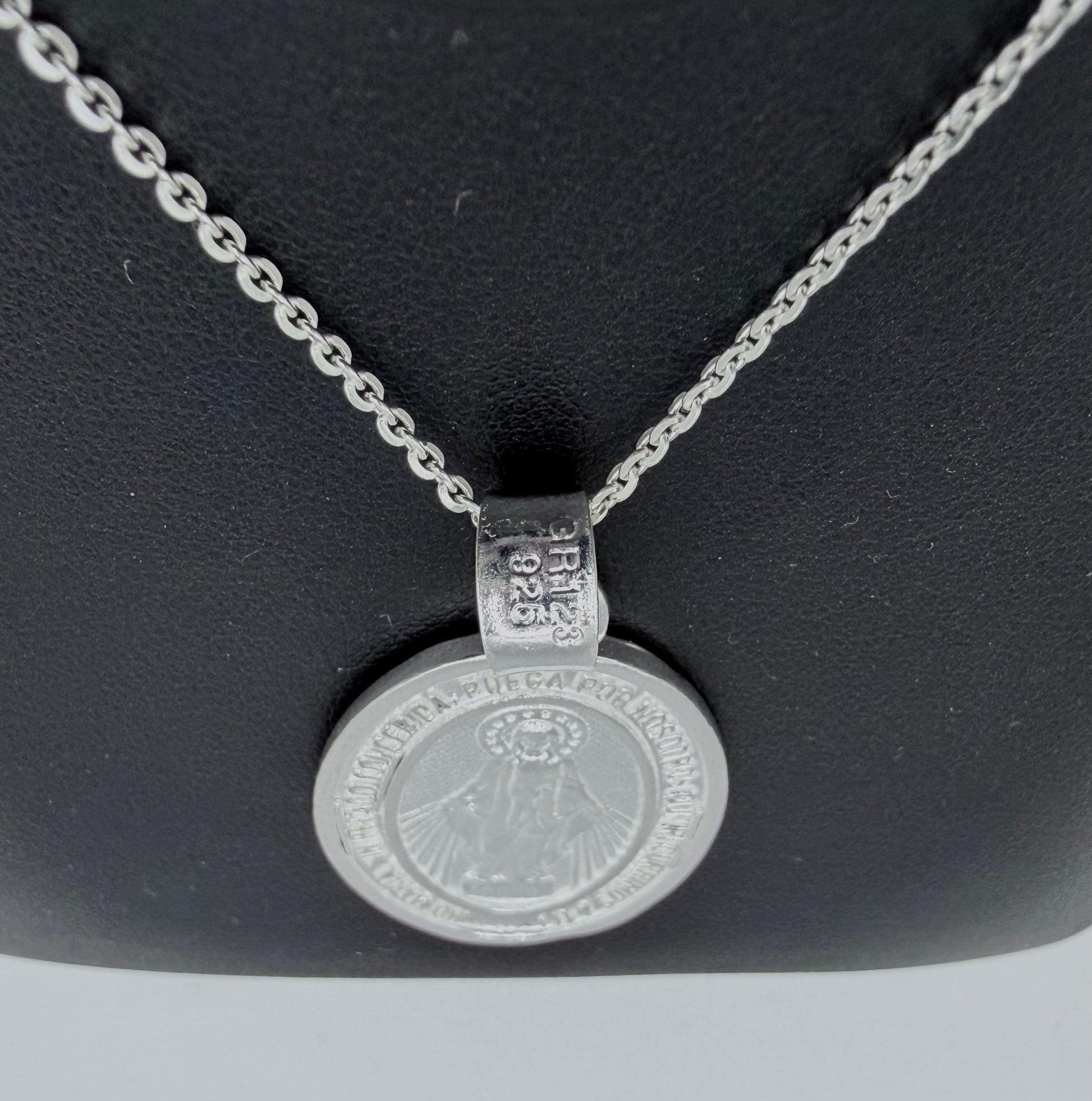 Detalle de medalla religiosa con relieve de la Virgen María, fundida en plata pura, con hallmark Taxco
