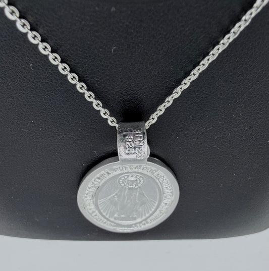 Detalle de medalla religiosa con relieve de la Virgen María, fundida en plata pura, con hallmark Taxco