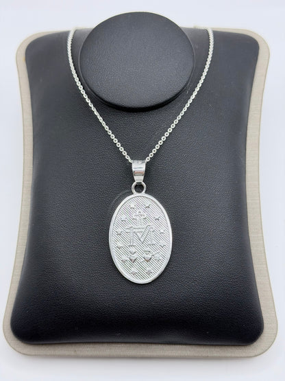 Vista frontal del collar completo: medalla de 4 cm de alto sobre cadena delicada de eslabón fino