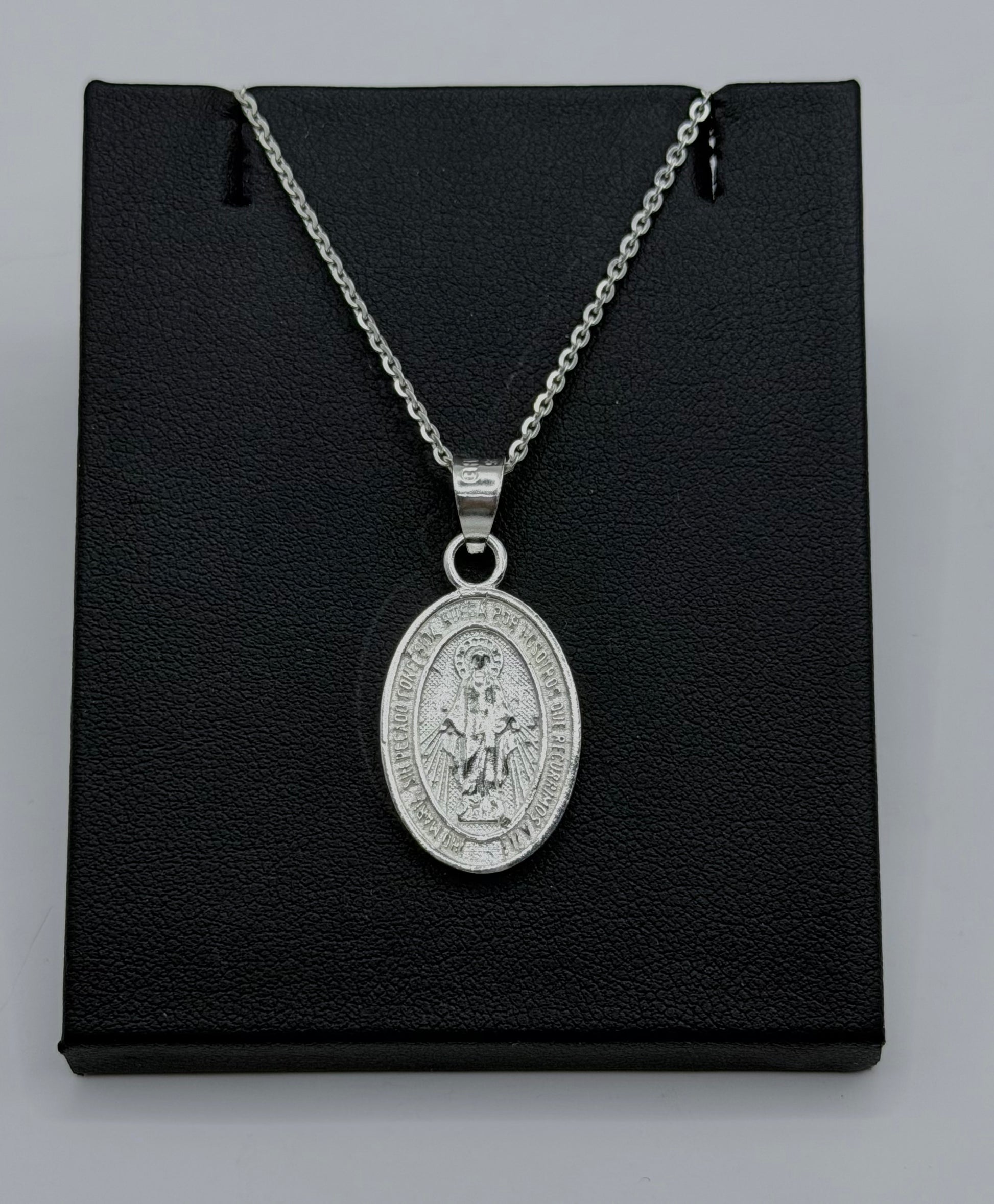 Medalla ovalada de la Virgen María en plata .925, grabada en relieve, colgada de cadena de eslabones de plata sobre fondo negro