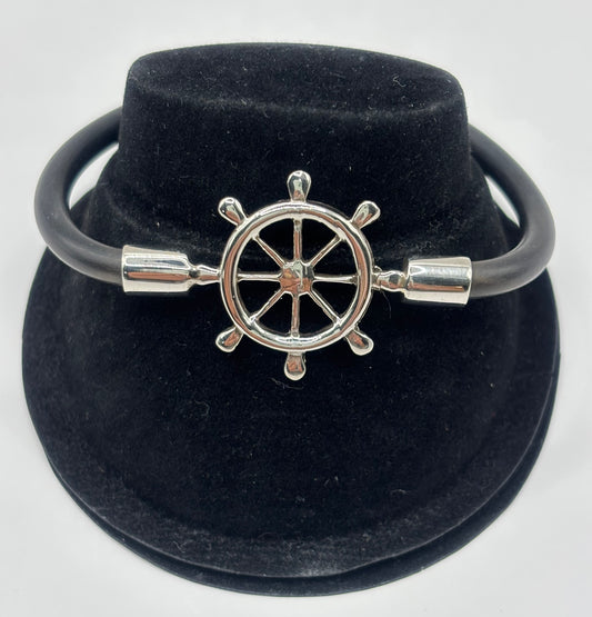 Pulsera timón náutico en plata .925 con cordón elástico negro, presentada en estuche de terciopelo