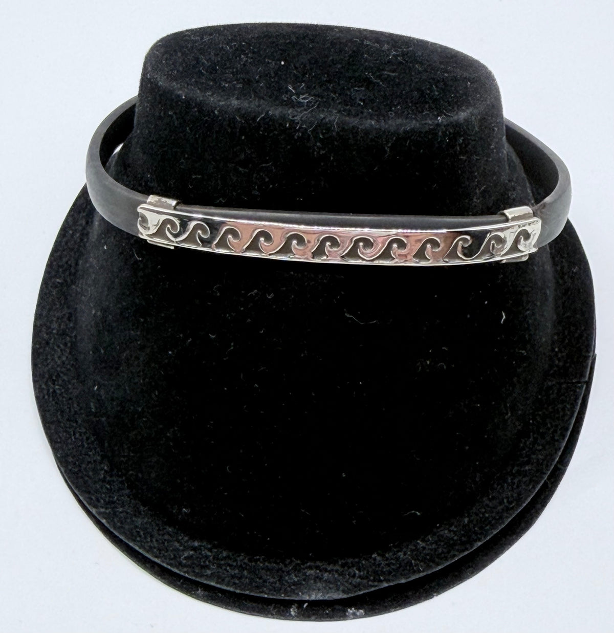 Pulsera de plata .925 con patrón de olas sobre caucho negro, vista frontal en forma de brazalete