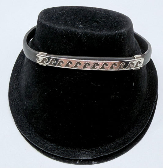 Pulsera de plata .925 con patrón de olas sobre caucho negro, vista frontal en forma de brazalete