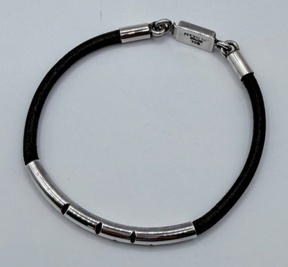 Vista lateral y abierta de la pulsera mostrando eslabones plateados alternados con segmentos de caucho negro