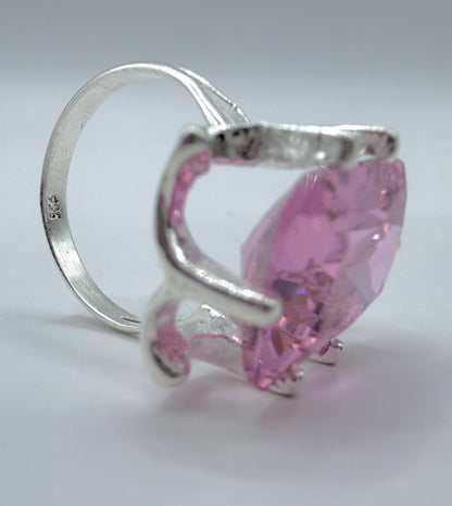 Detalle lateral del anillo mostrando el engaste de prong que sostiene la circonia rosa facetada