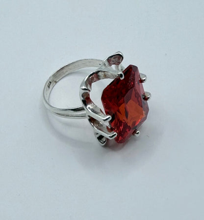 Vista frontal del anillo circonia roja con brillo intenso y facetas cristalinas visibles
